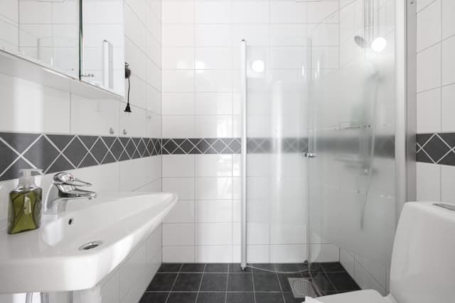 Ljust lägenhetsinteriör i Sundbyberg med minimalistisk inredning och grönskande omgivningar