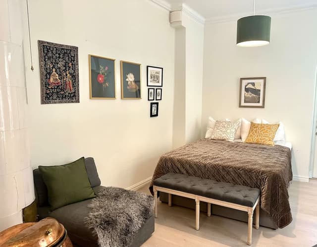 Solbelyst sovrum med stora fönster och högt i tak i en Airbnb i Gamla Stan, nära Stortorget och Kungliga slottet