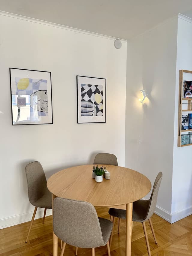 Vardagsrum i Södermalmslägenhet med matbord, bäddsoffa och läshörna