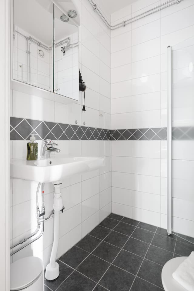 Ljust lägenhetsinteriör i Sundbyberg med minimalistisk inredning och grönskande omgivningar