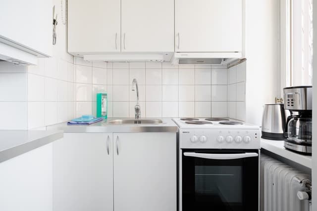 Interior of a Hornstull studio in Södermalm with modern kitchen, double bed and balcony view
