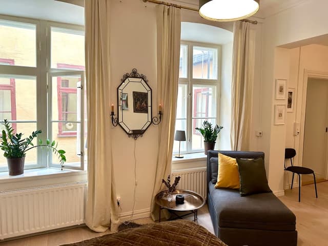 Solbelyst sovrum med stora fönster och högt i tak i en Airbnb i Gamla Stan, nära Stortorget och Kungliga slottet