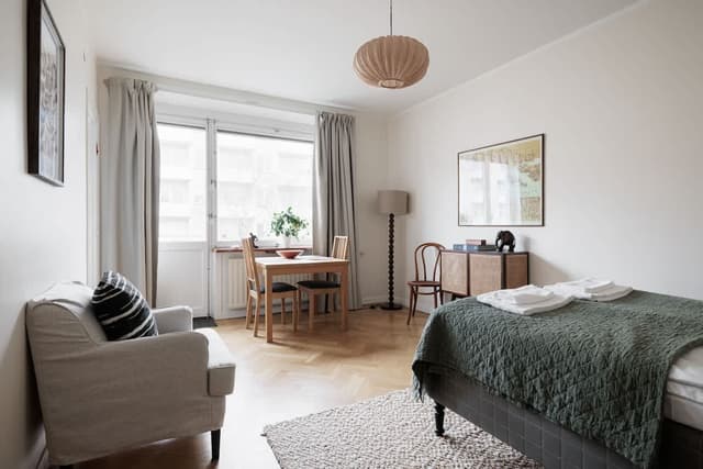 Stockholm studiolägenhet, 140 cm säng, matbord för två, kompakt kök, fåtölj, hall