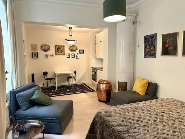 Solbelyst sovrum med stora fönster och högt i tak i en Airbnb i Gamla Stan, nära Stortorget och Kungliga slottet