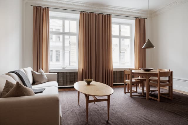 Interiör från stilren lägenhet i Östermalm, Stockholm, med öppen planlösning, trägolv & marmorbadrum