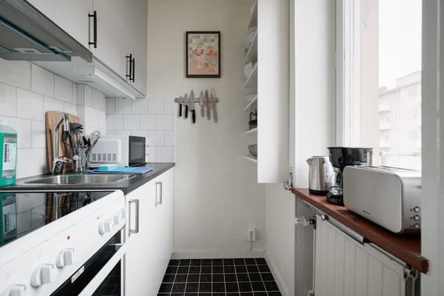 Stockholm studiolägenhet, 140 cm säng, matbord för två, kompakt kök, fåtölj, hall