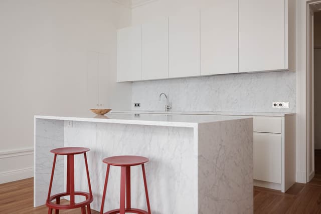 Interiör från stilren lägenhet i Östermalm, Stockholm, med öppen planlösning, trägolv & marmorbadrum