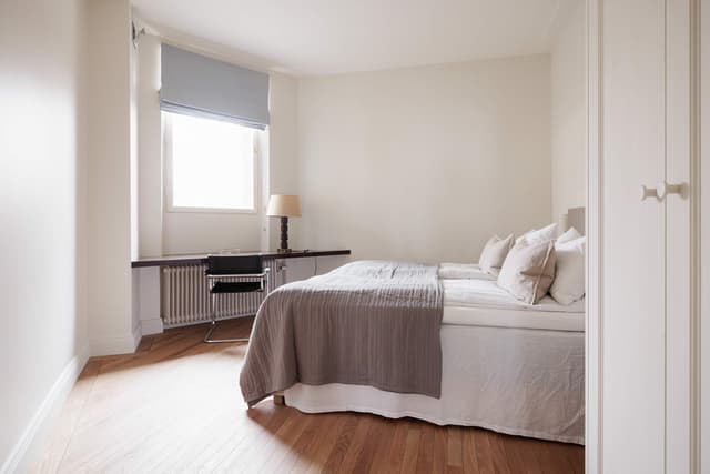 Interiör från stilren lägenhet i Östermalm, Stockholm, med öppen planlösning, trägolv & marmorbadrum